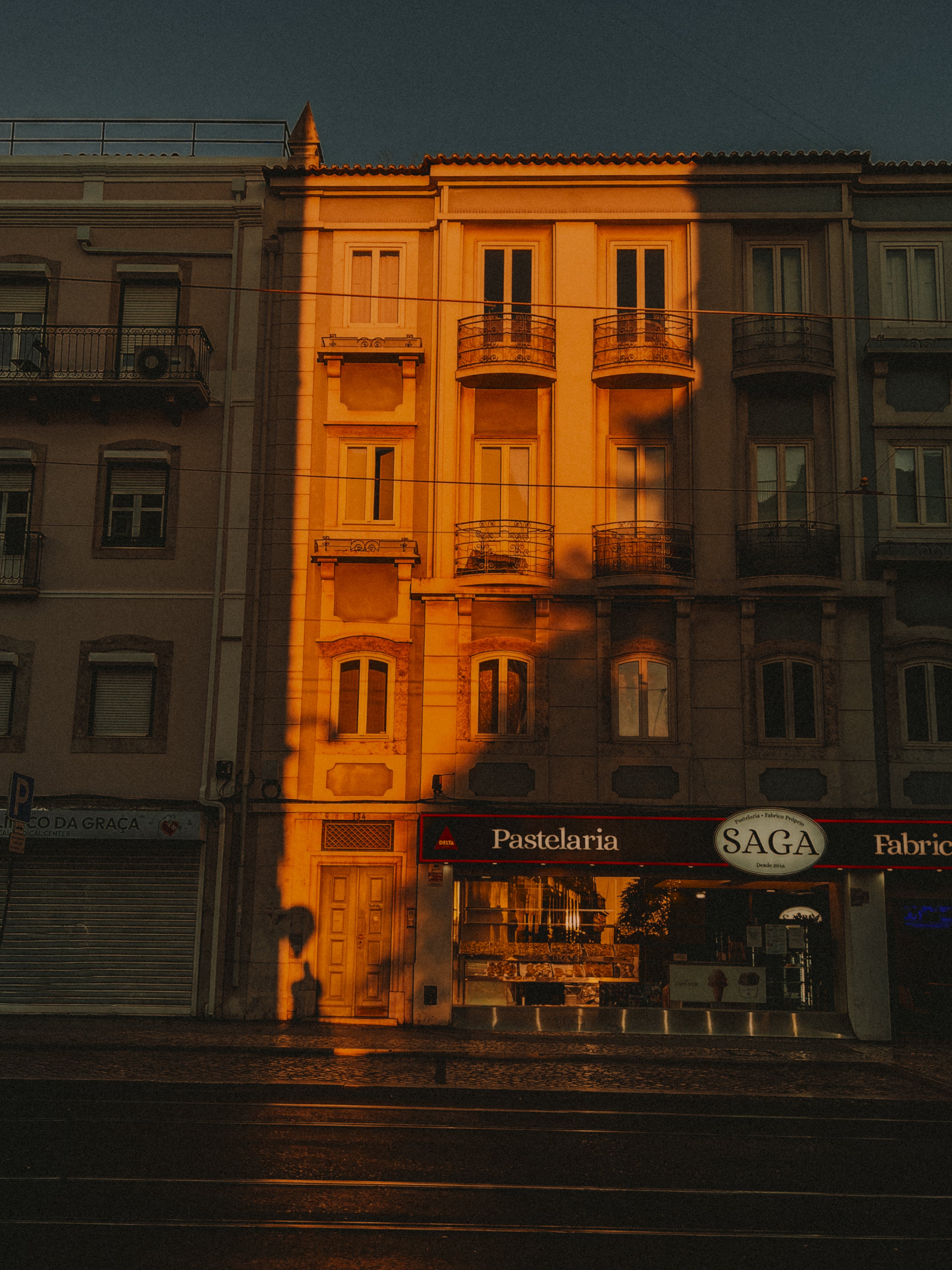Pastelaria SAGA facade with golden light stripe — Rua da Graça, Lisbon