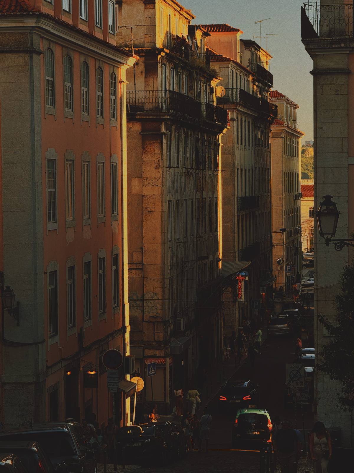 Lisbon in Golden Recession, Cais do Sodré, Lisbon — Layered facades recede into shadow at golden hour on Rua das Flores — warm plaster, iron balconies, characteristic Lisbon depth.