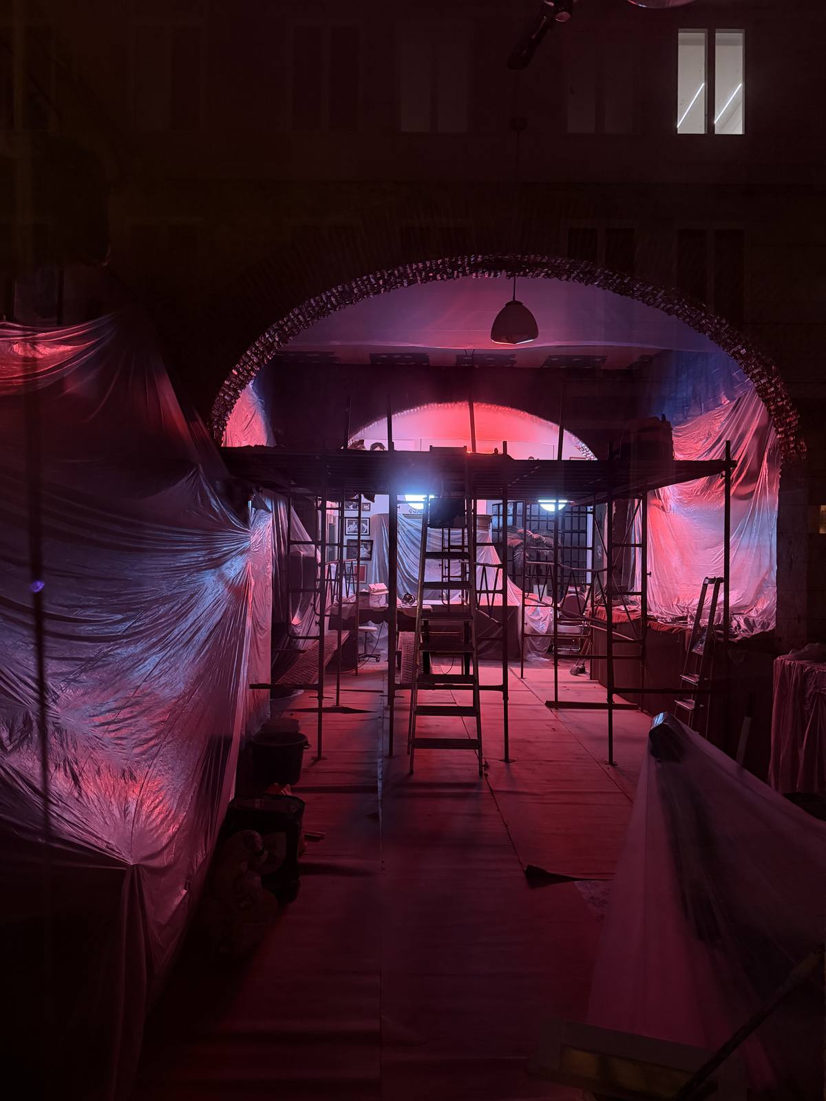 Portal, Pink Dark, Cais do Sodré, Lisbon — Massive circular arch glows crimson-pink inside a dark industrial shell under construction — surreal depth, controlled dramatic light, nothing else in the ba