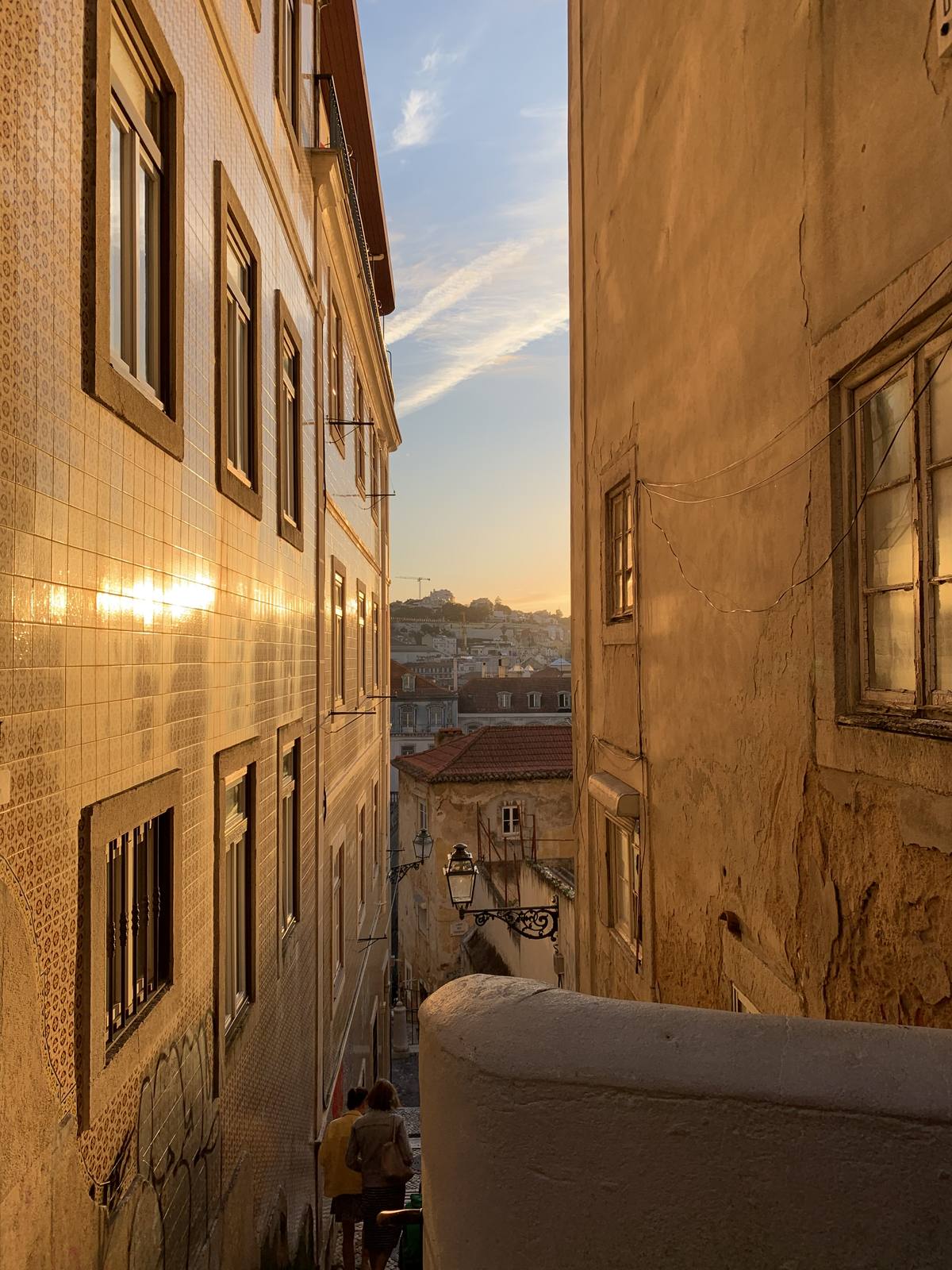 Golden Wall Rising, Mouraria, Lisbon — Worm's-eye compression of tiled azulejo facade catching warm late light — strong vertical lines, restraint, classic ABIASSI upward-gaze.