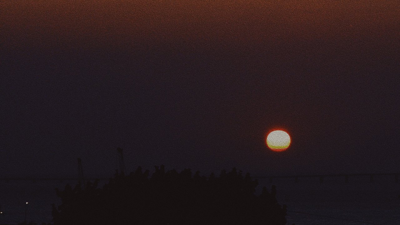 Sun setting over the silhouetted Lisbon skyline at the end of golden hour